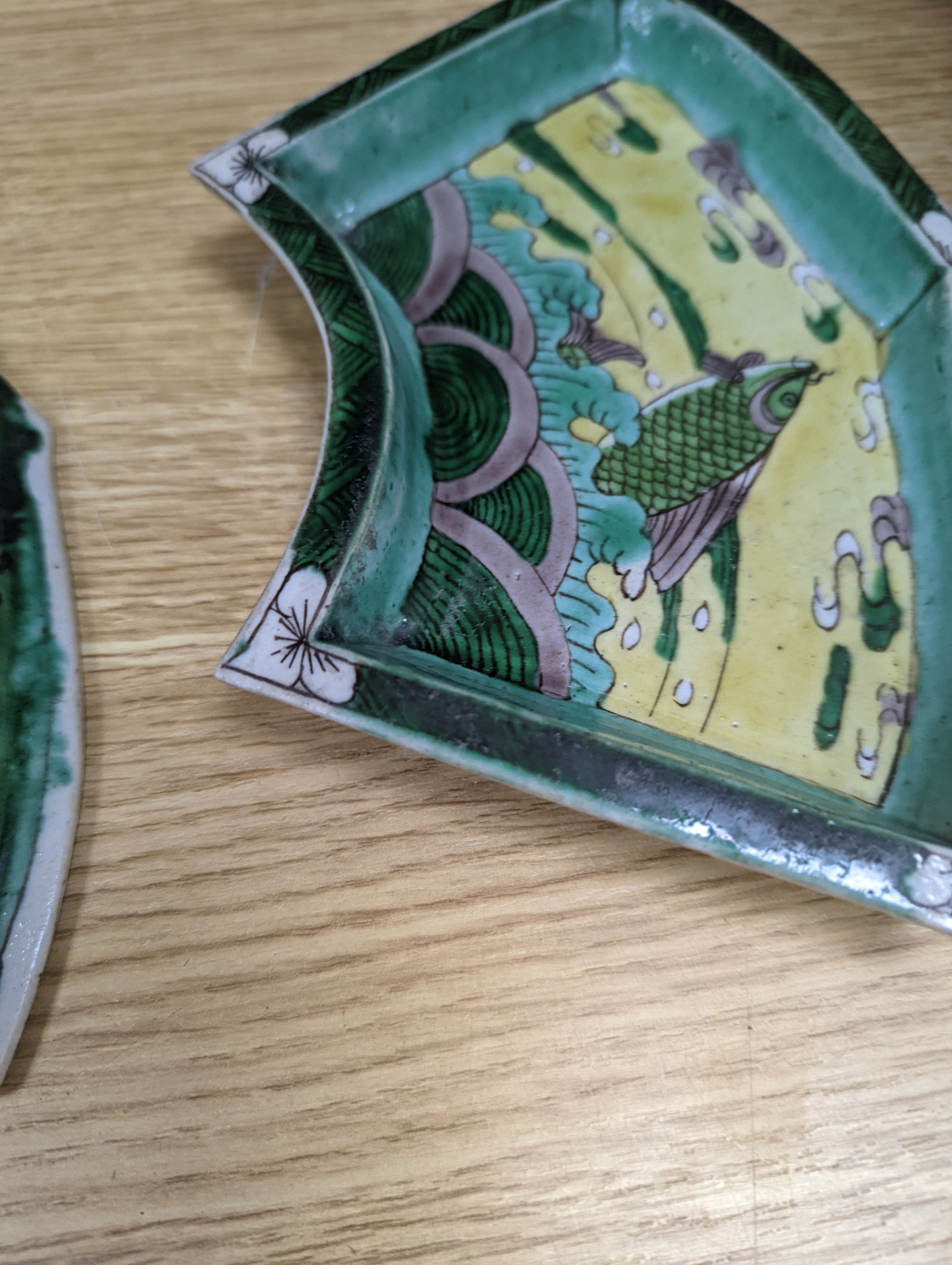 A pair of Chinese famille verte biscuit fan-shaped sweetmeat dishes, Kangxi, 20 cms wide.